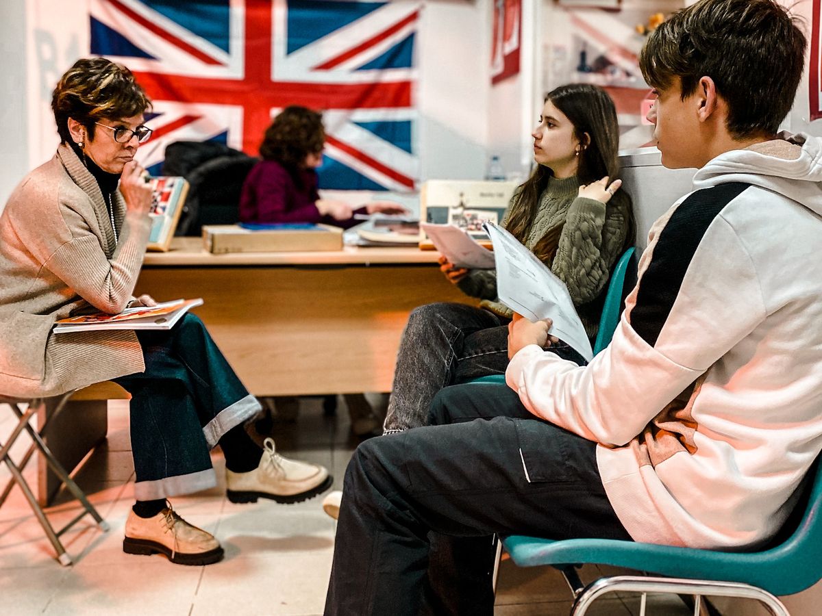 Profesora con alumnos jóvenes y adultos
